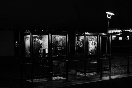 Phone booths near the harbor with graffiti at night